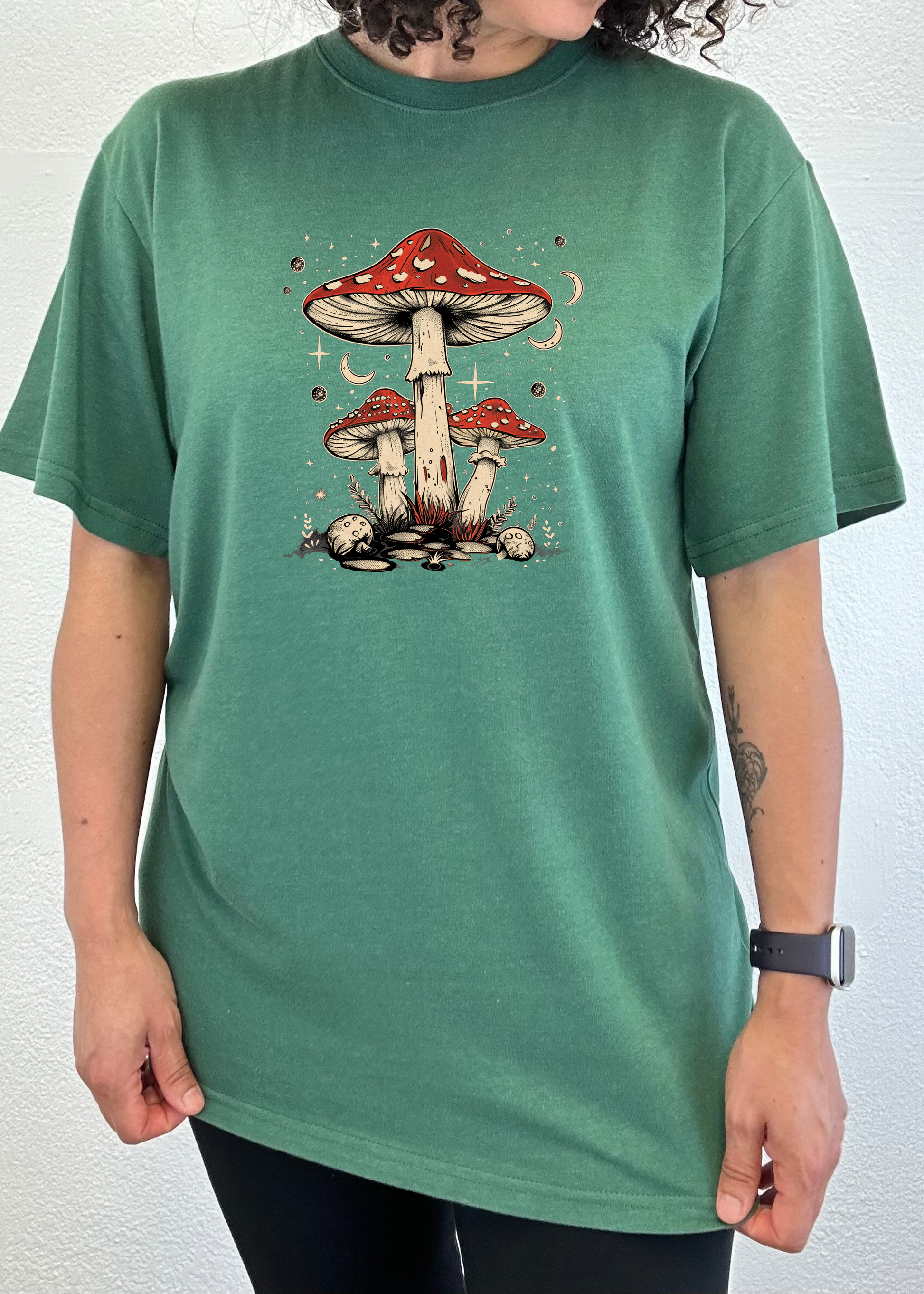 Unisex graphic t-shirt in teal green with red mushroom artwork centered