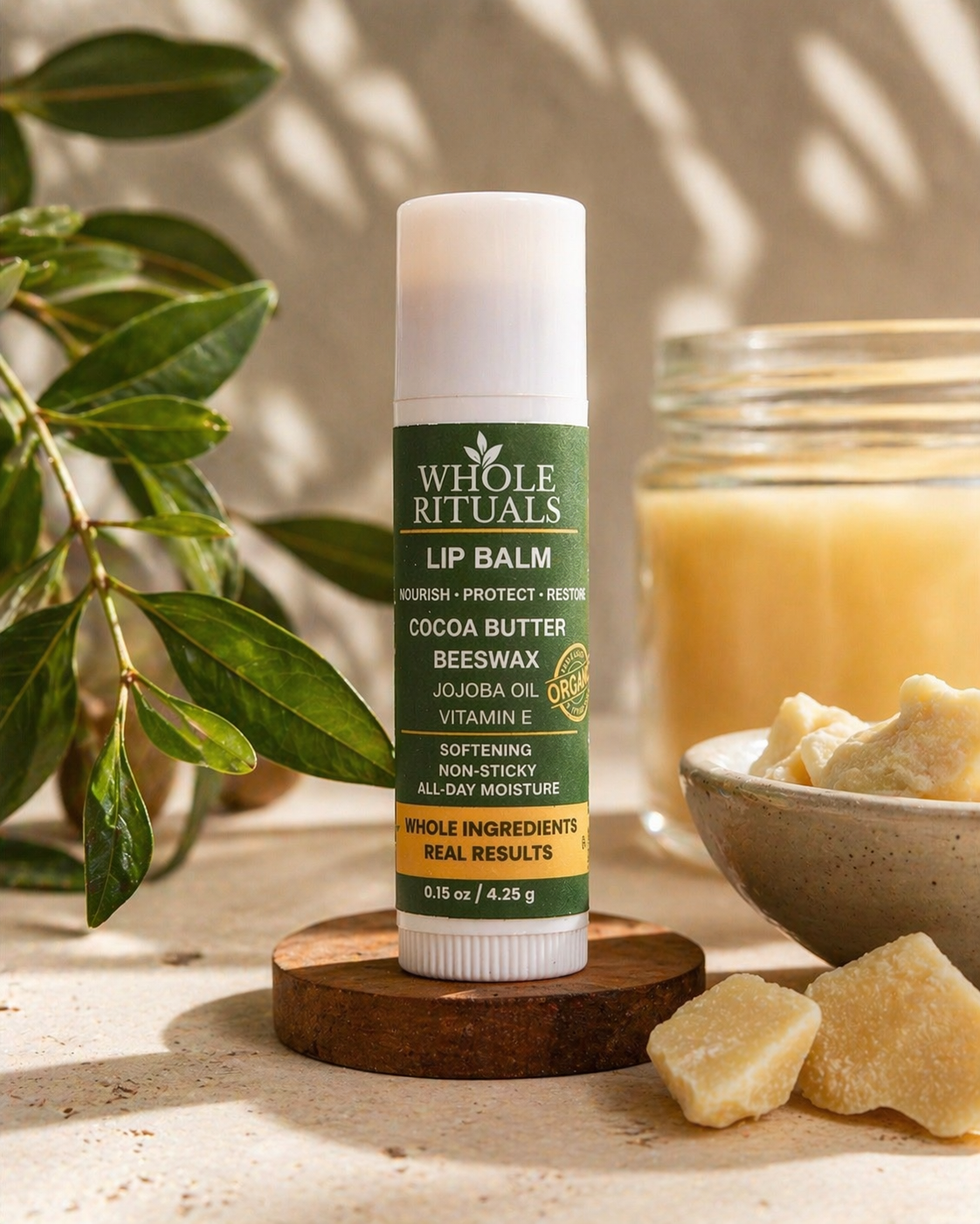 Whole Rituals cocoa butter lip balm stick with green label, cocoa butter chunks nearby