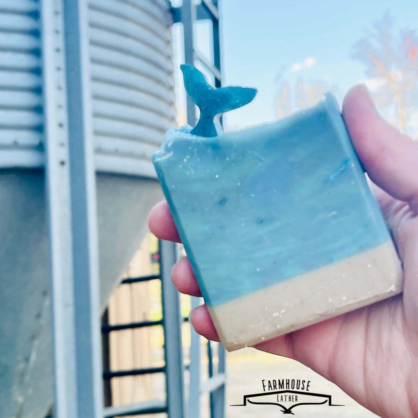 Seaside Stables soap bar, light blue with starfish top, beige base, held in hand
