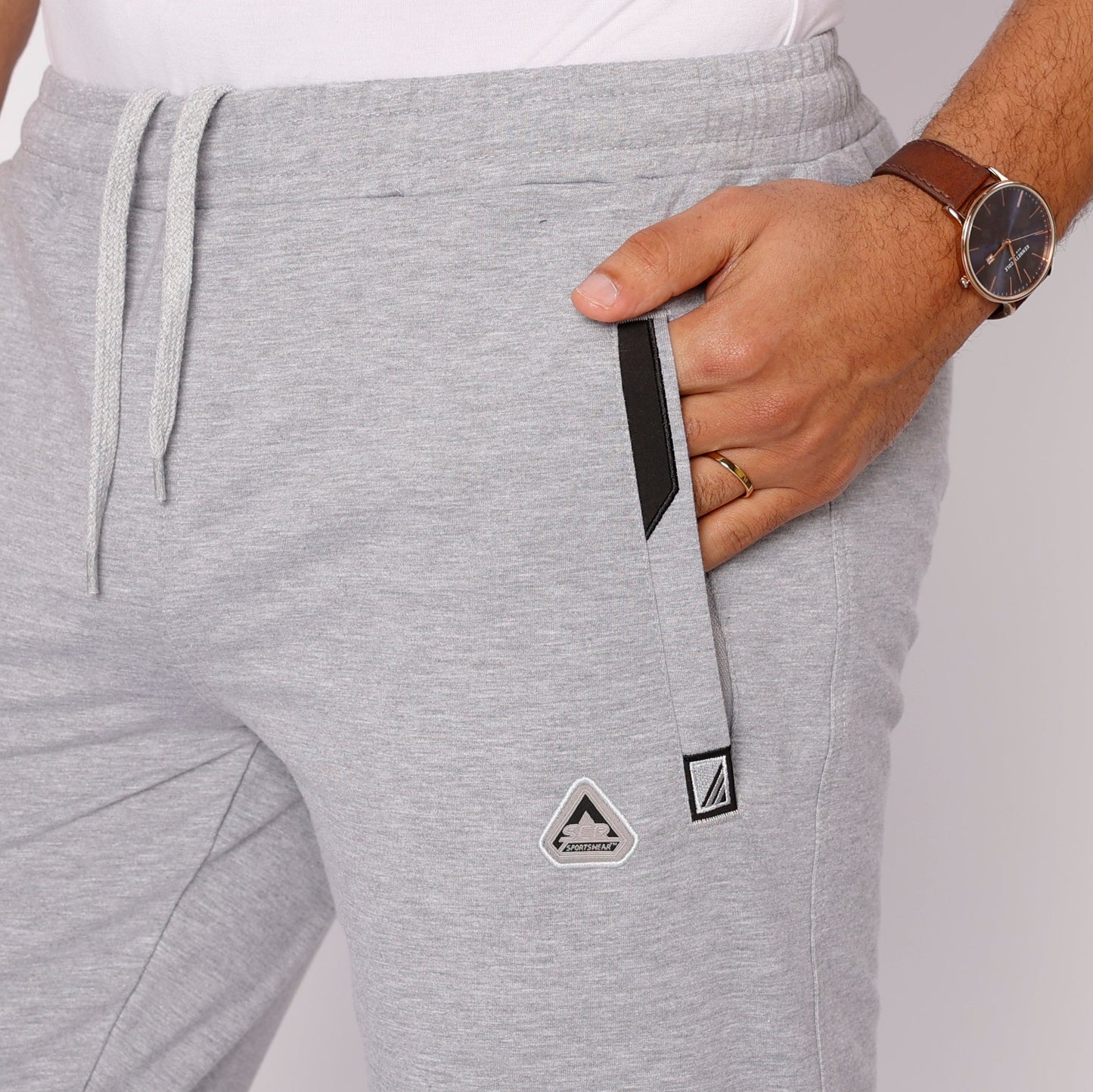Light gray tapered sweatpants with drawstring and logo patch on hip