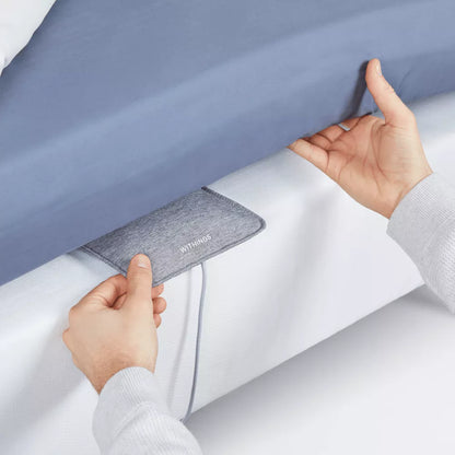 Withings sleep tracking mat placed under bedsheet on white mattress