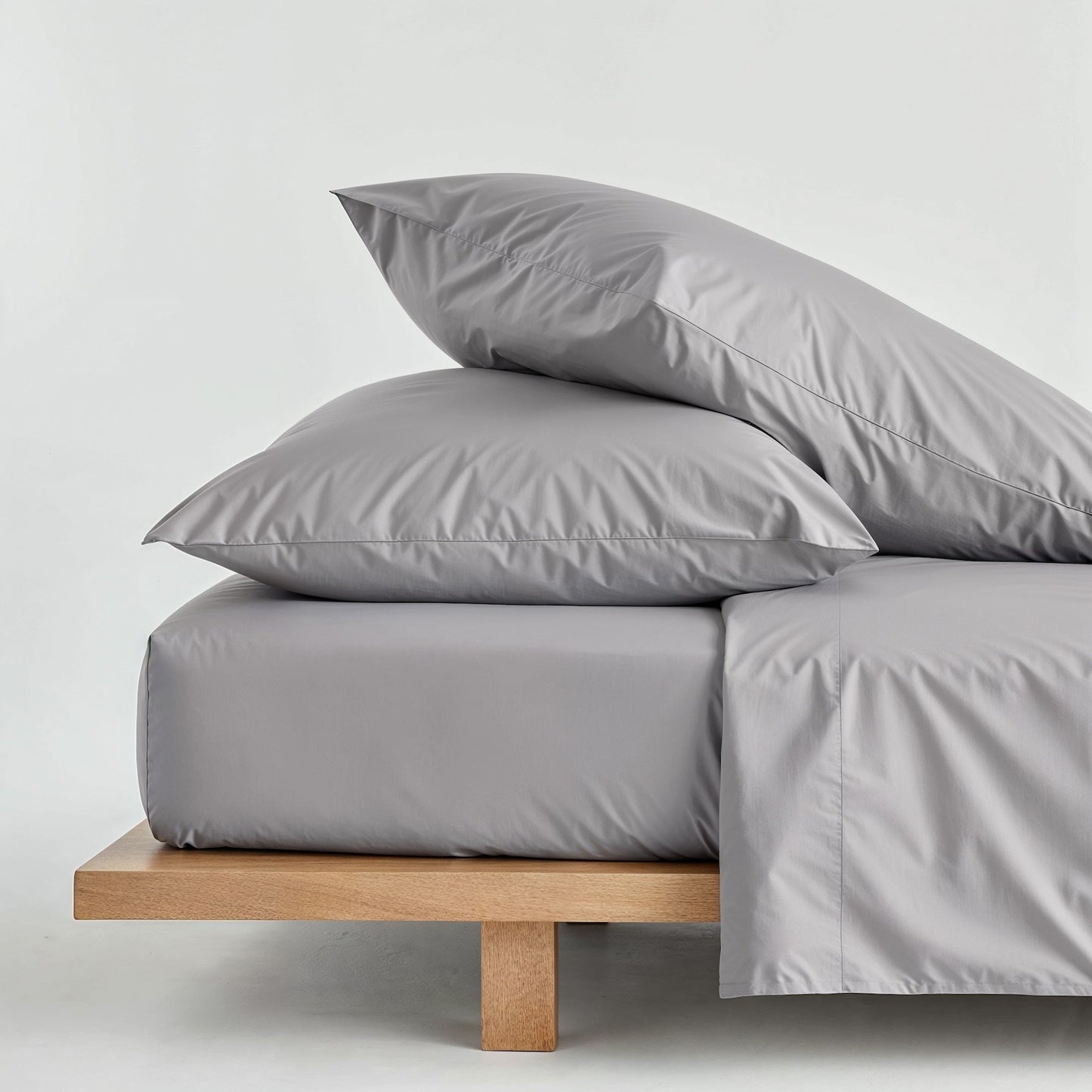 Light gray sateen duvet cover with two matching pillows on a bed