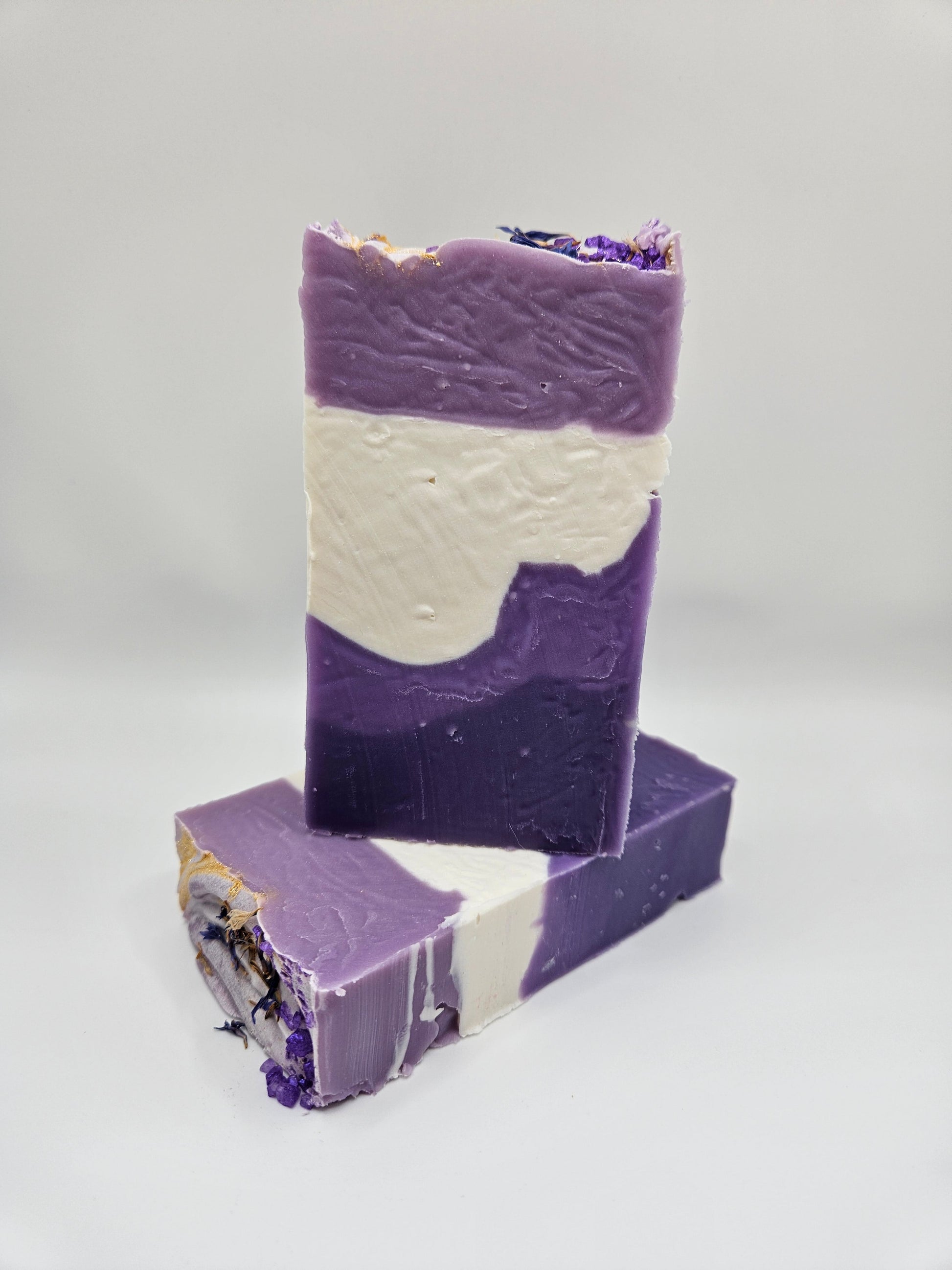 Lavender artisan soap bar with purple and cream layers, topped with dried flowers