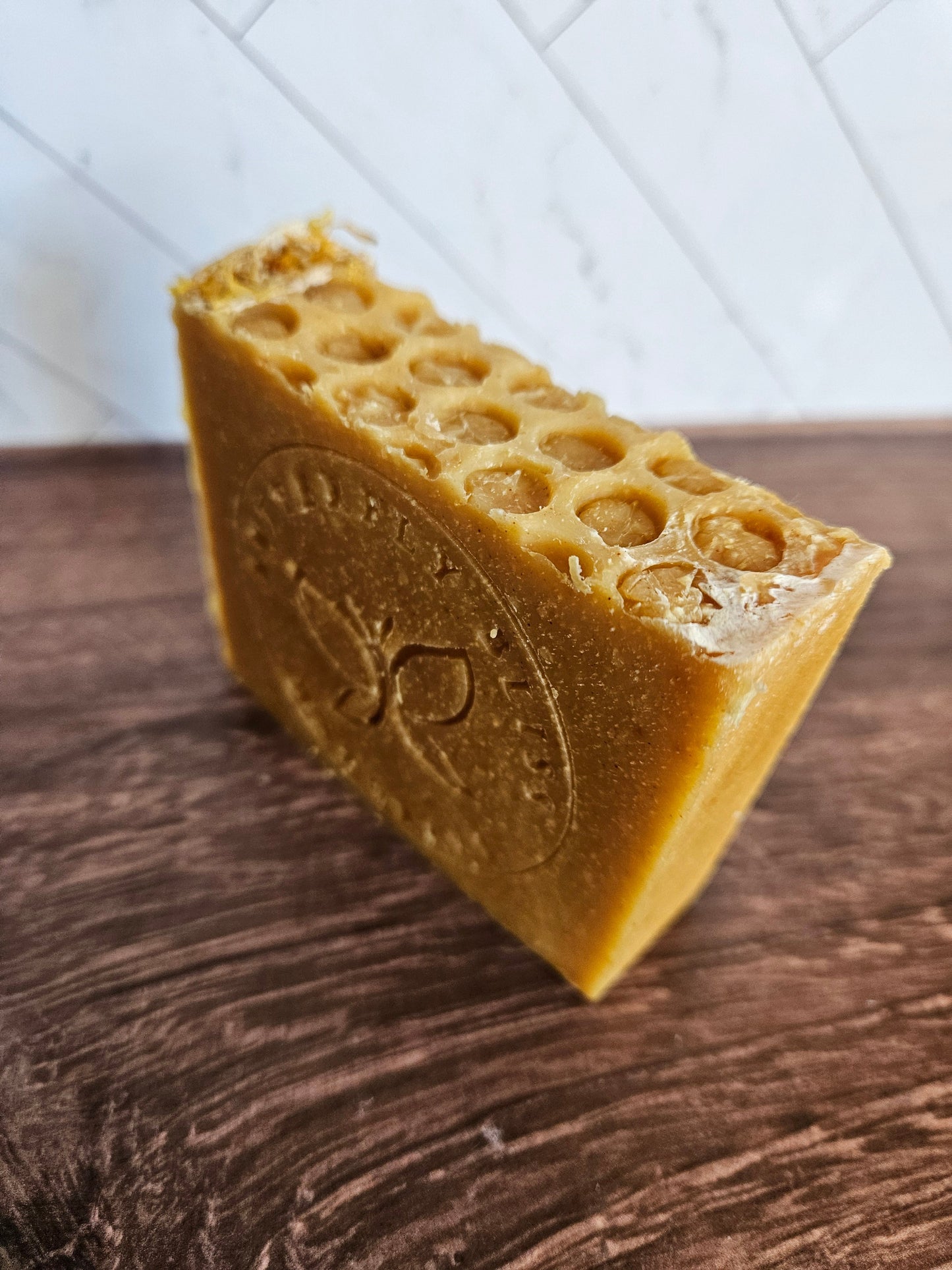 Turmeric and Honey coconut milk soap bar, golden with round soap holes on top.