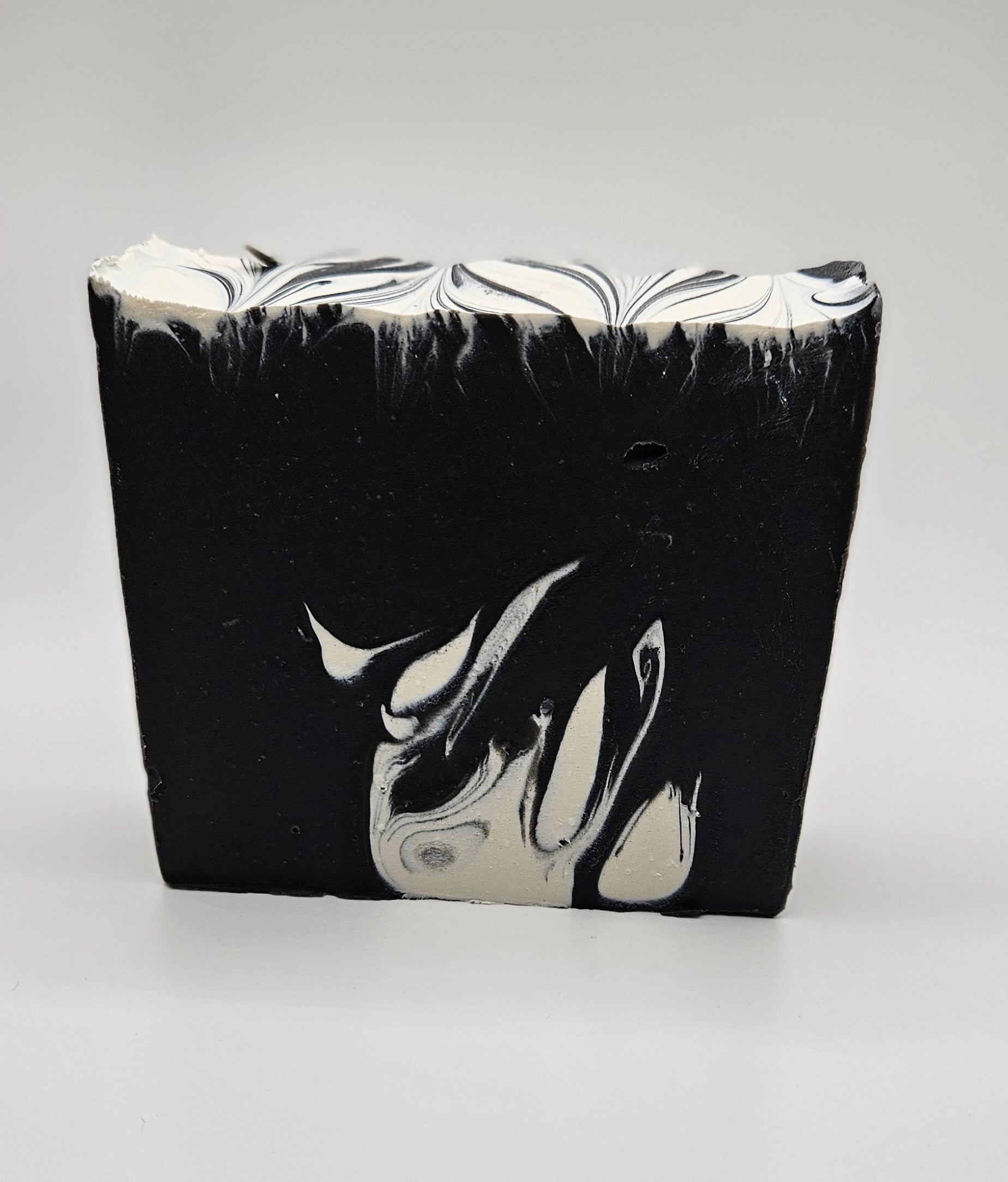 Artisan soap bar, dark charcoal with white marbled swirls and wavy top