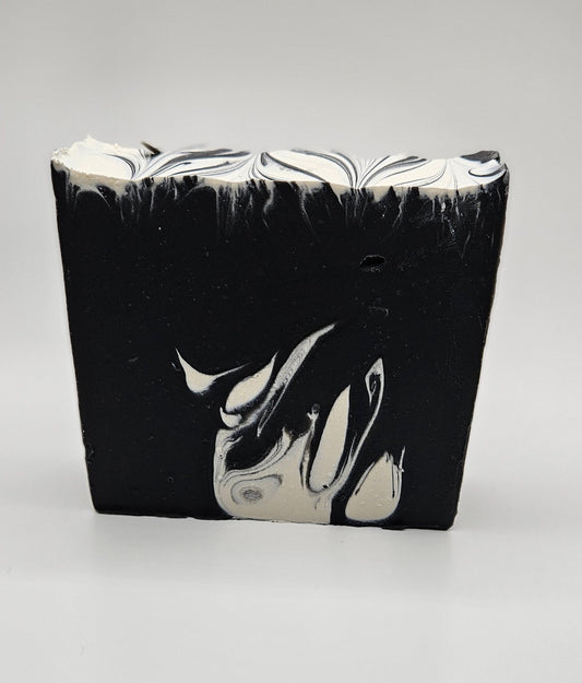 Artisan soap bar, dark charcoal with white marbled swirls and wavy top