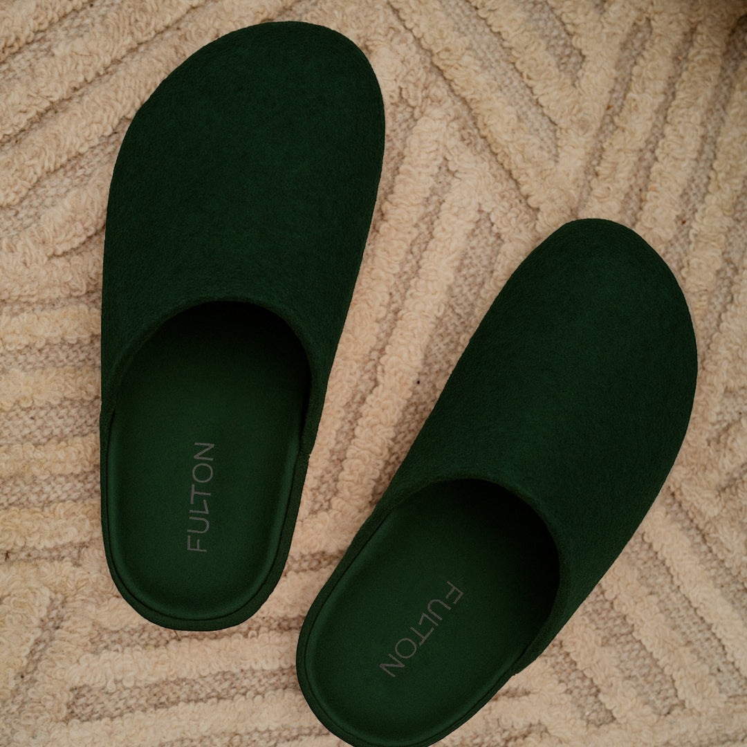 Forest green suede open-heel house slippers, pair view with FULTON logo on insoles.