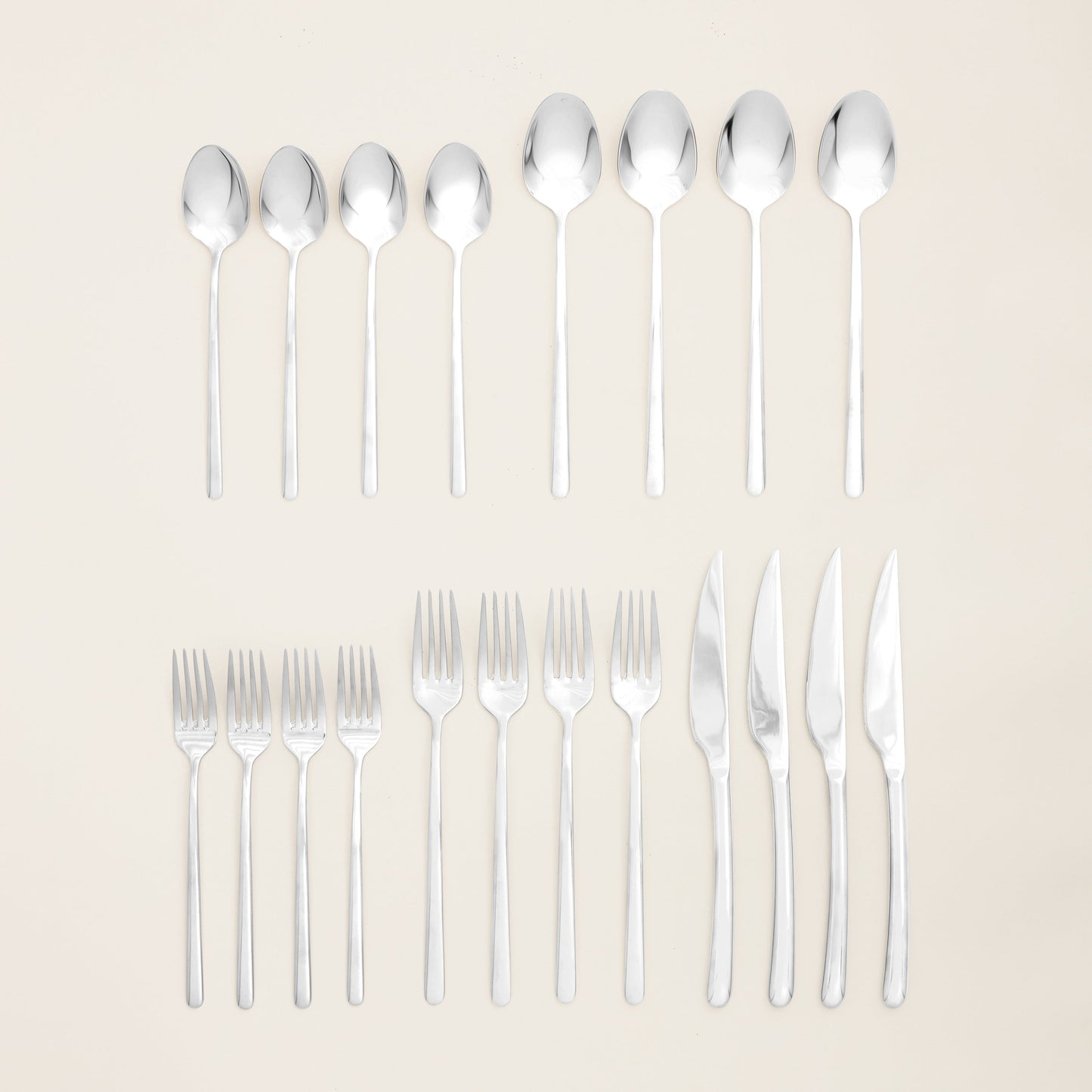 Silver flatware set with forks and spoons arranged in two rows
