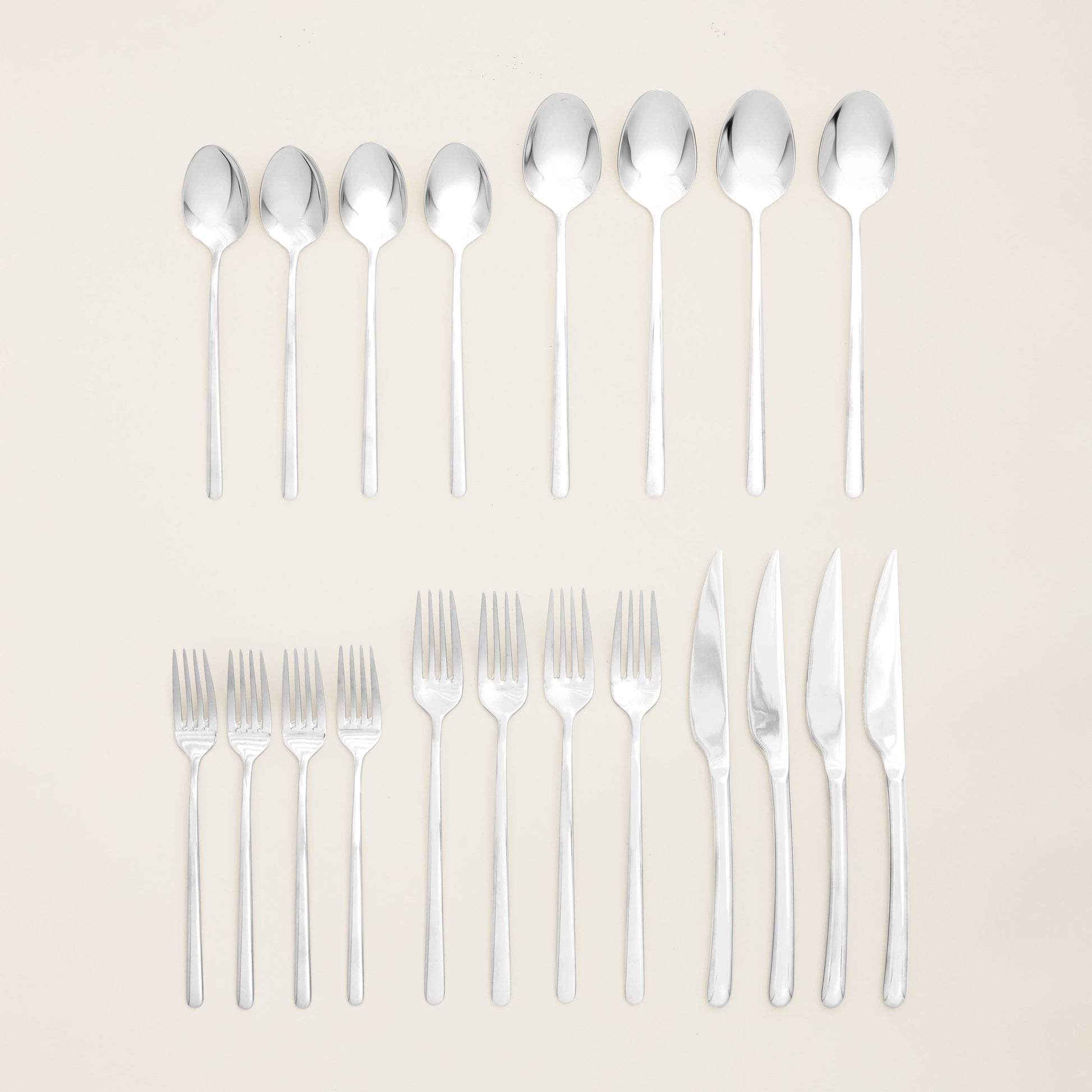 Silver flatware set with forks and spoons arranged in two rows