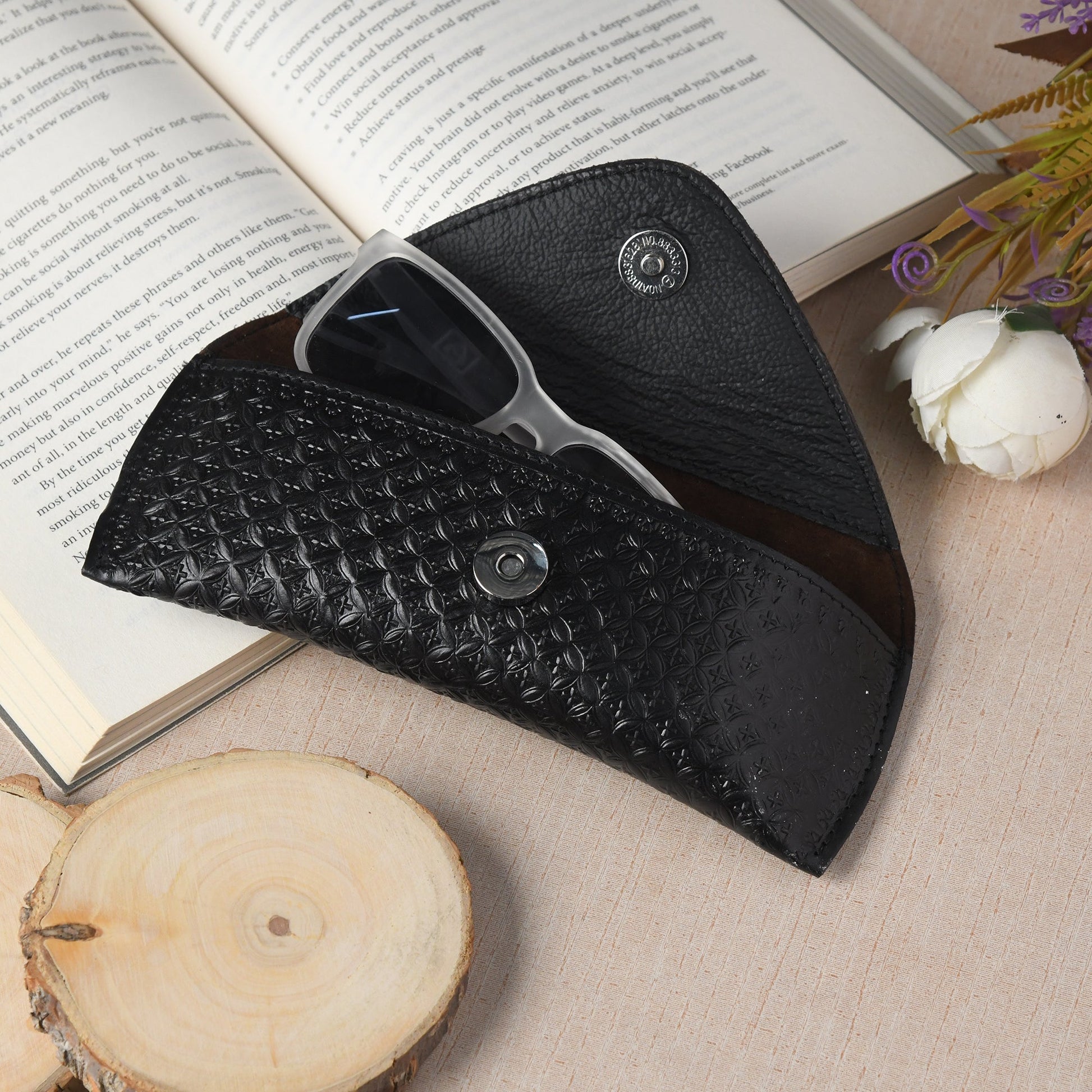 Black textured leather sunglasses cover, open showing eyeglass frame inside