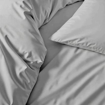 Sateen sheet set in light gray, close-up of smooth bedding fabric
