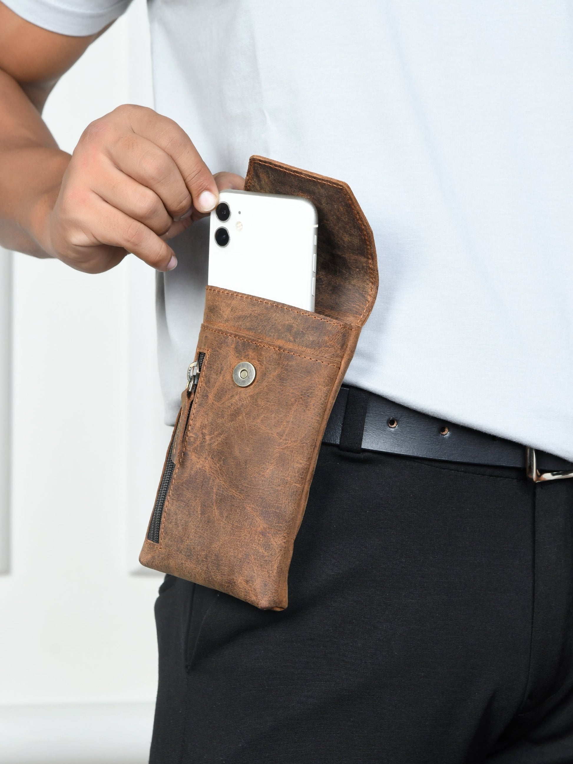 Brown leather holster case on belt with phone partially inside