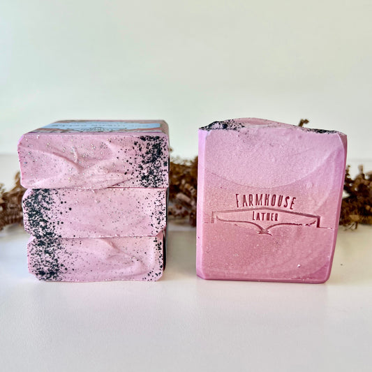 Purple speckled goat milk soap bars, one showing FARMHOUSE LATTER stamp