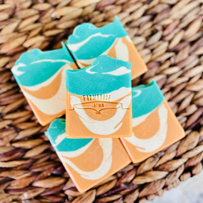 Set of layered soap bars in orange and teal with white emblem