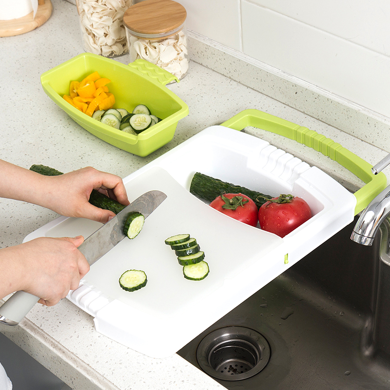 White plastic chopping board with green rim and removable food prep tray