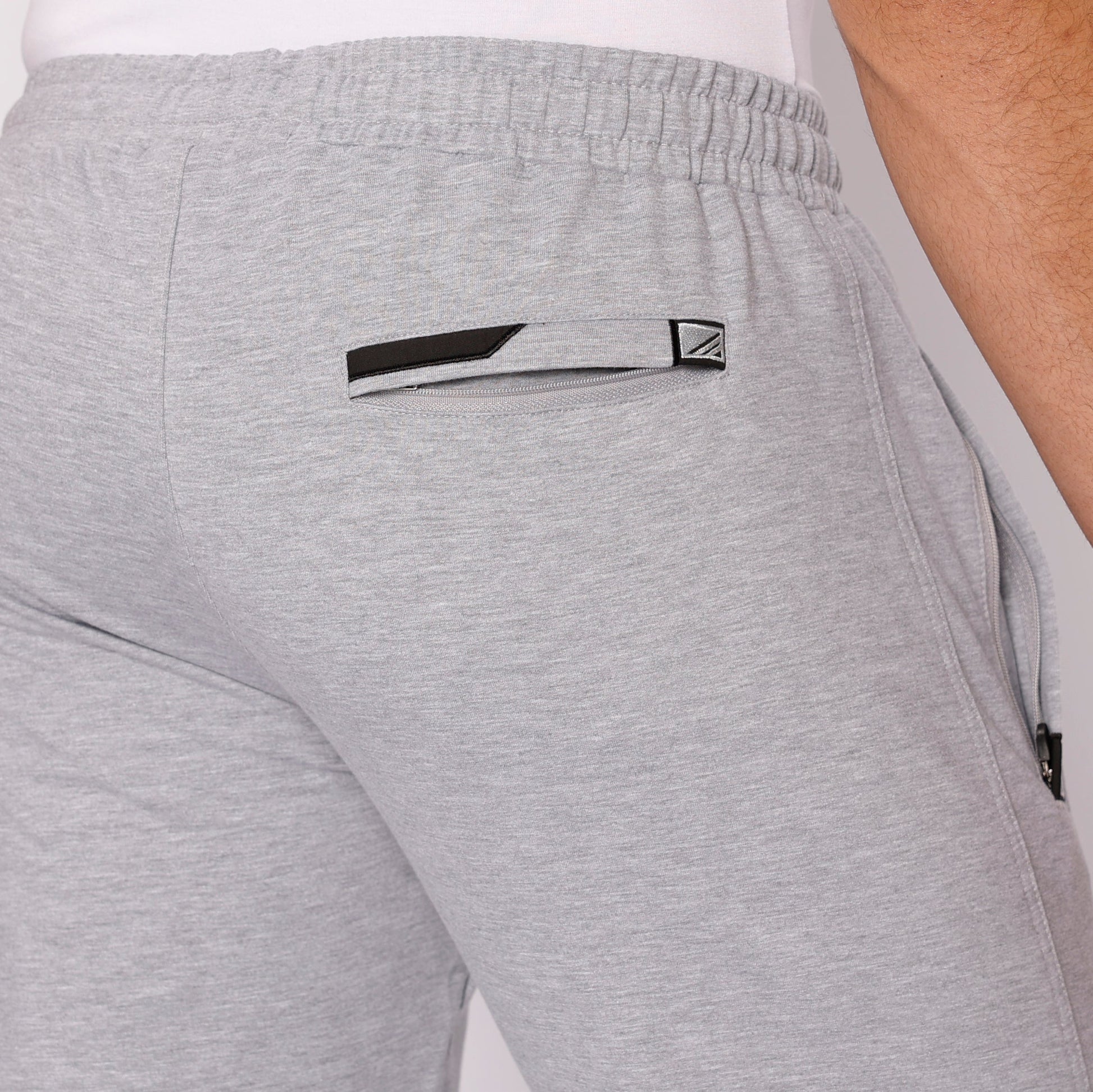 Light gray athletic sweatpants with tapered leg, elastic waistband, logo tab