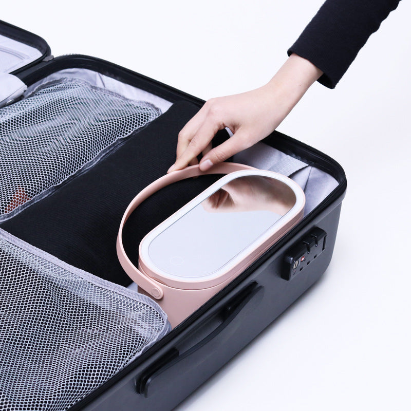 Makeup organizer case with pink tray and white handle, open inside with accessory slots
