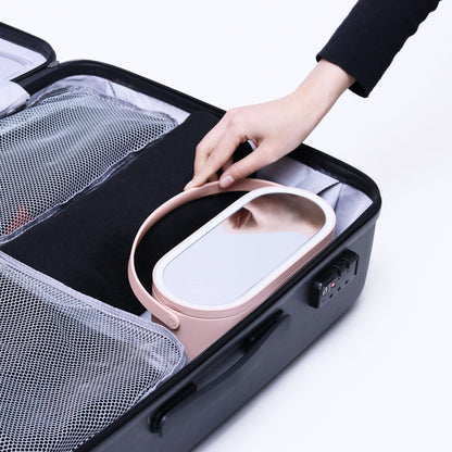 Makeup organizer case with pink tray and white handle, open inside with accessory slots