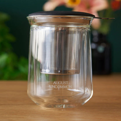 Clear tasting glass with perforated metal insert inside; AUGUST UNCOMMON etched