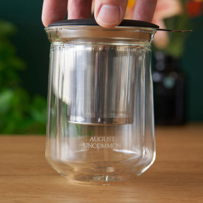 Clear tasting glass with perforated metal insert; AUGUST UNCOMMON etched on base