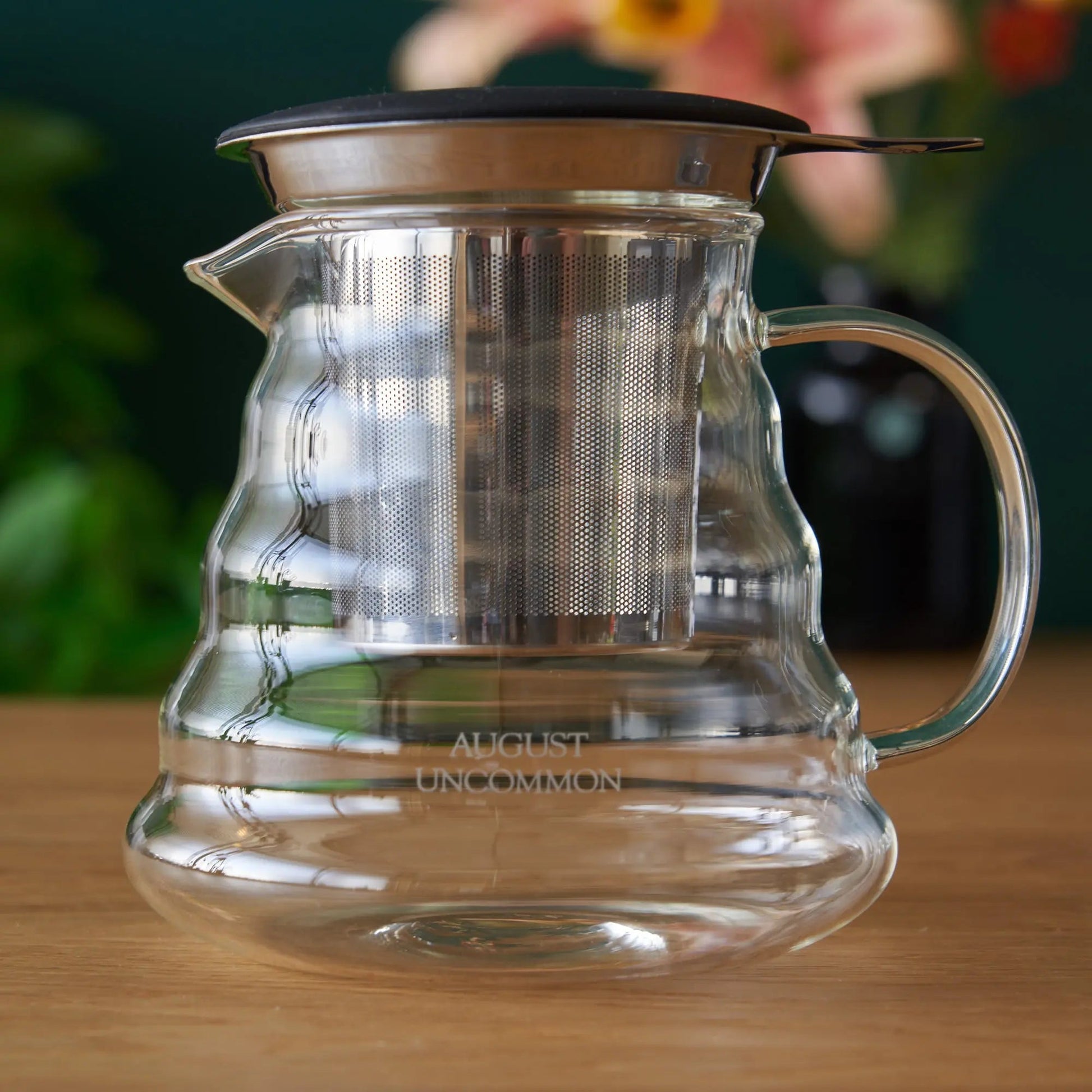 Two-cup glass teapot with perforated metal infuser lid and clear side handle.