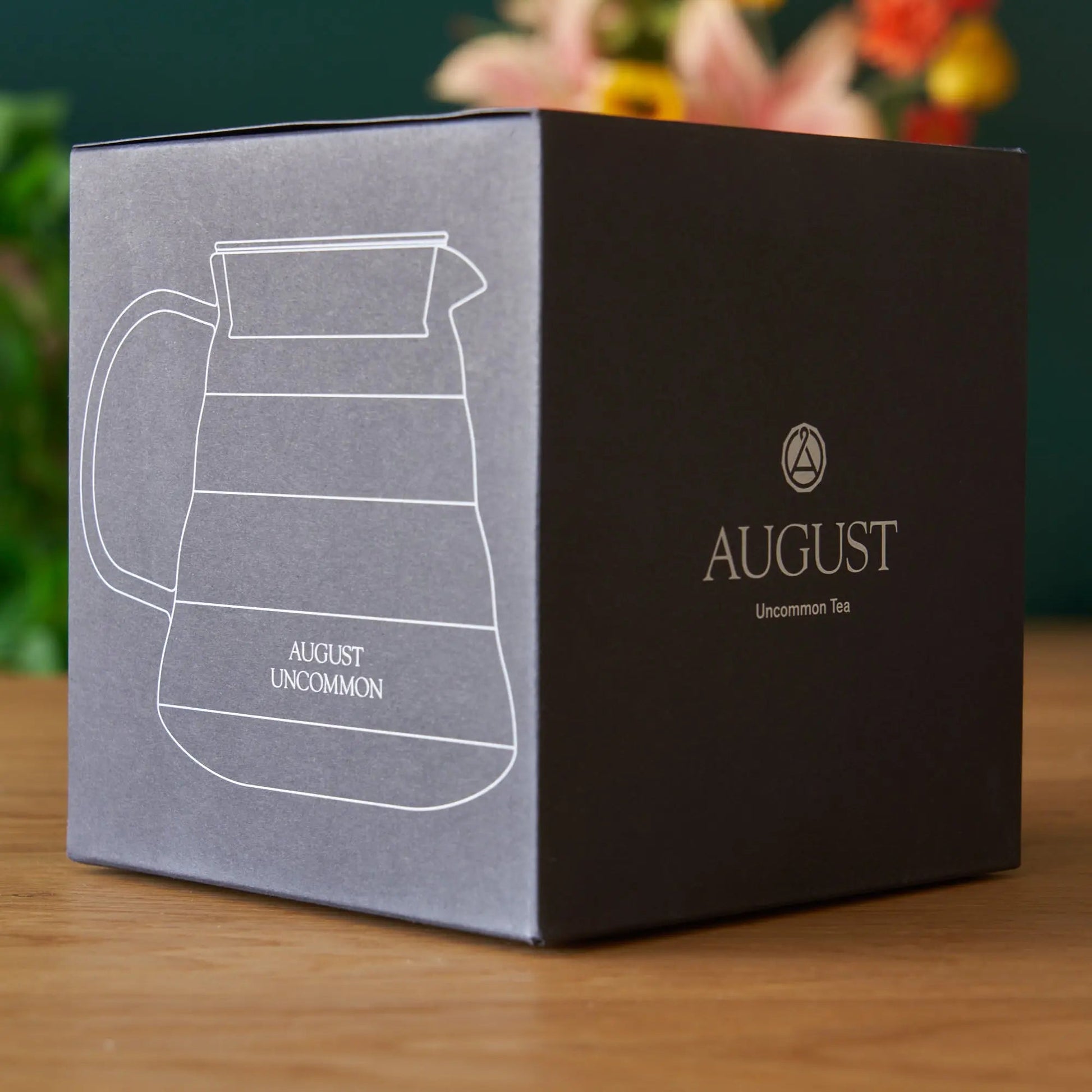 Glass teapot gift box with teapot line drawing and AUGUST Uncommon Tea logo