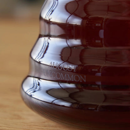 Close-up of glass teapot with amber tea and embossed side pattern.