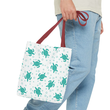 Sea turtle pattern tote bag with teal repeating turtles, held by red carry handles