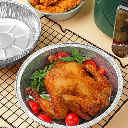 Round foil liner pan with a baked chicken and greens on an air fryer rack