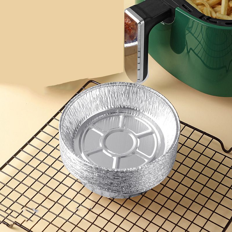 Round aluminum foil air fryer liner pan on wire rack, crimped rim and center insert