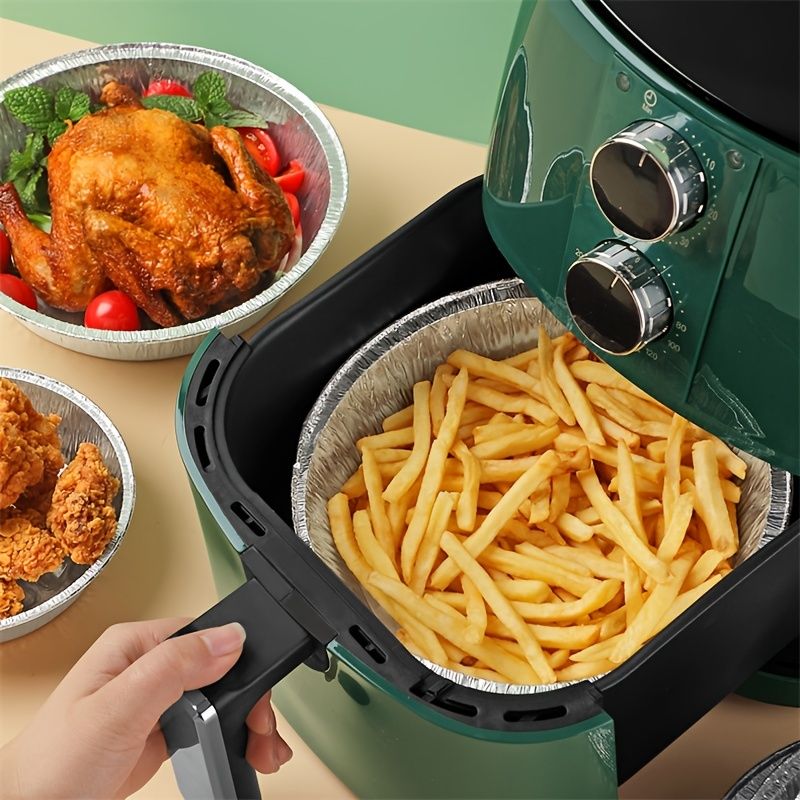 Round aluminum foil air fryer liner pan with crimped rim, holds food in basket
