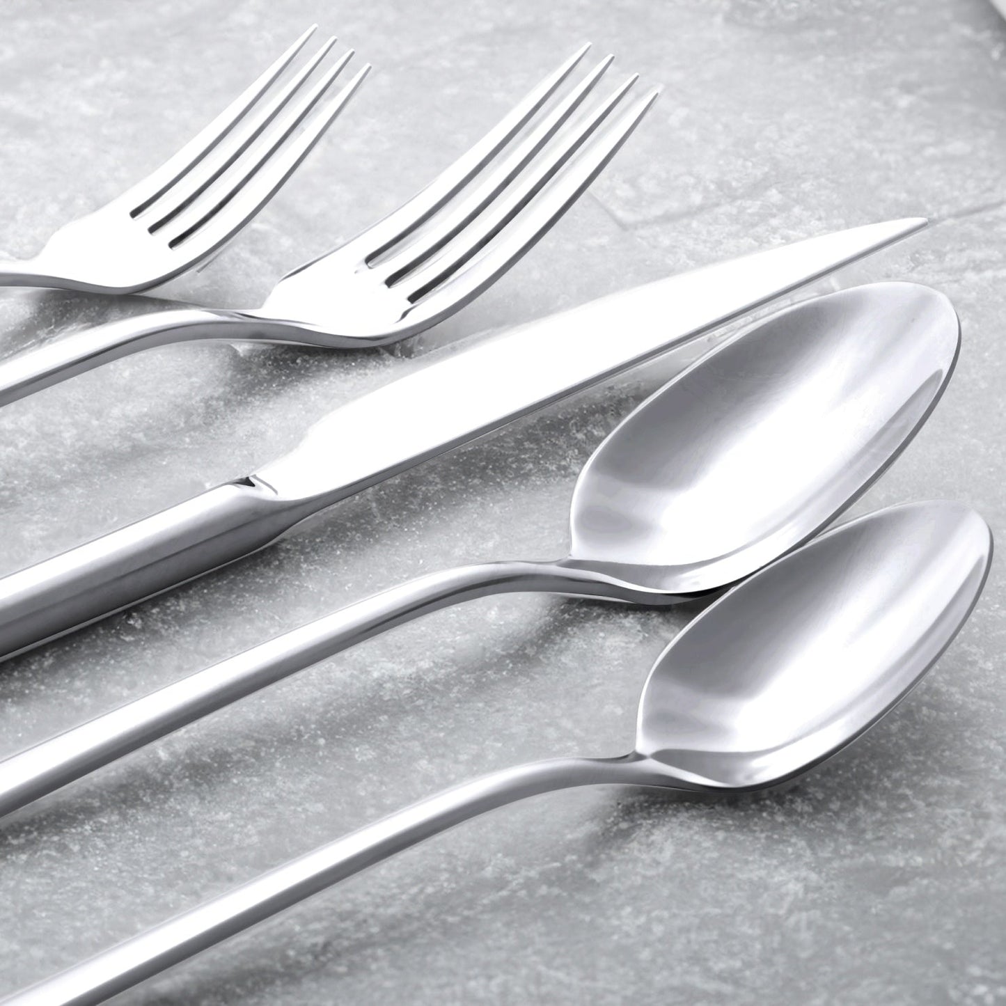 Close-up of silver forks and spoons with reflective polished bowls