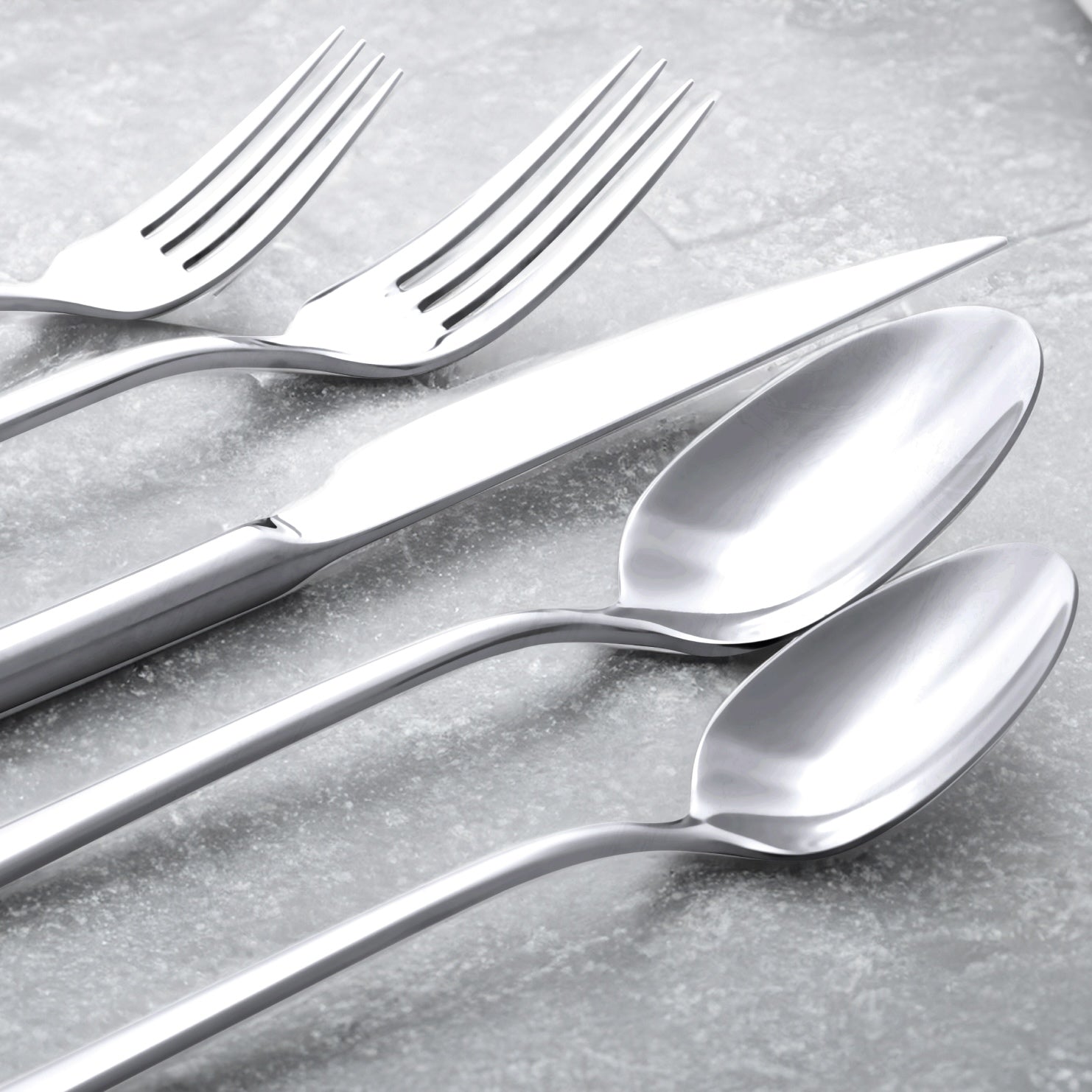 Close-up of silver forks and spoons with reflective polished bowls