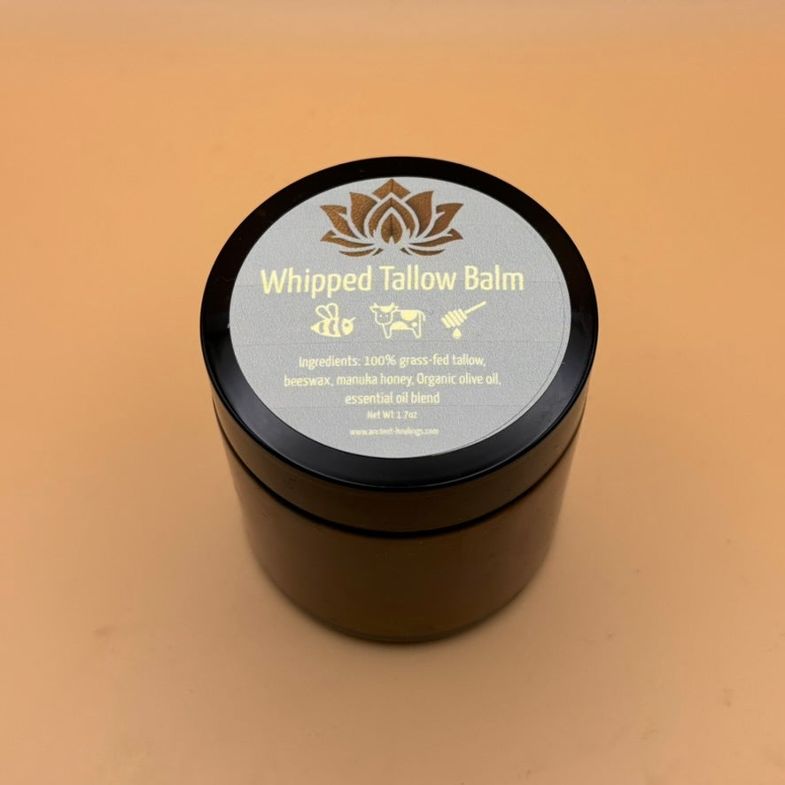 Tallow balm jar with black lid and blue label featuring golden icons and text