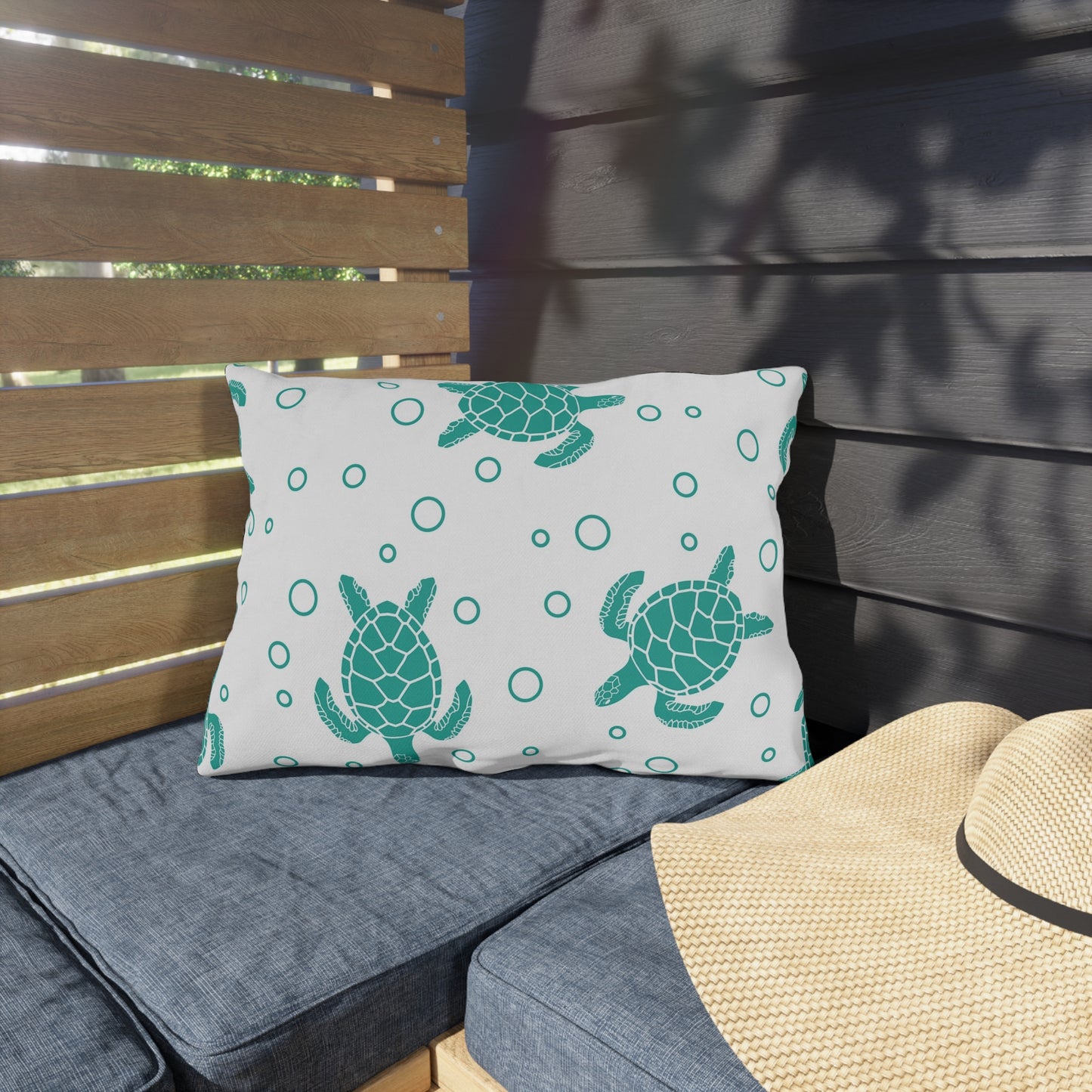 Square outdoor cushion pillow with teal sea turtle print and ring dots on white fabric.
