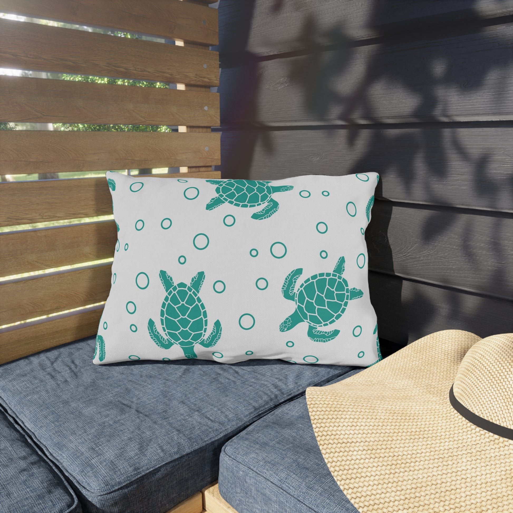 Square outdoor cushion pillow with teal sea turtle print and ring dots on white fabric.