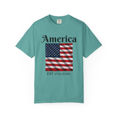 Teal T-shirt with “America” over US flag and “EST 1776-2026” graphic on front