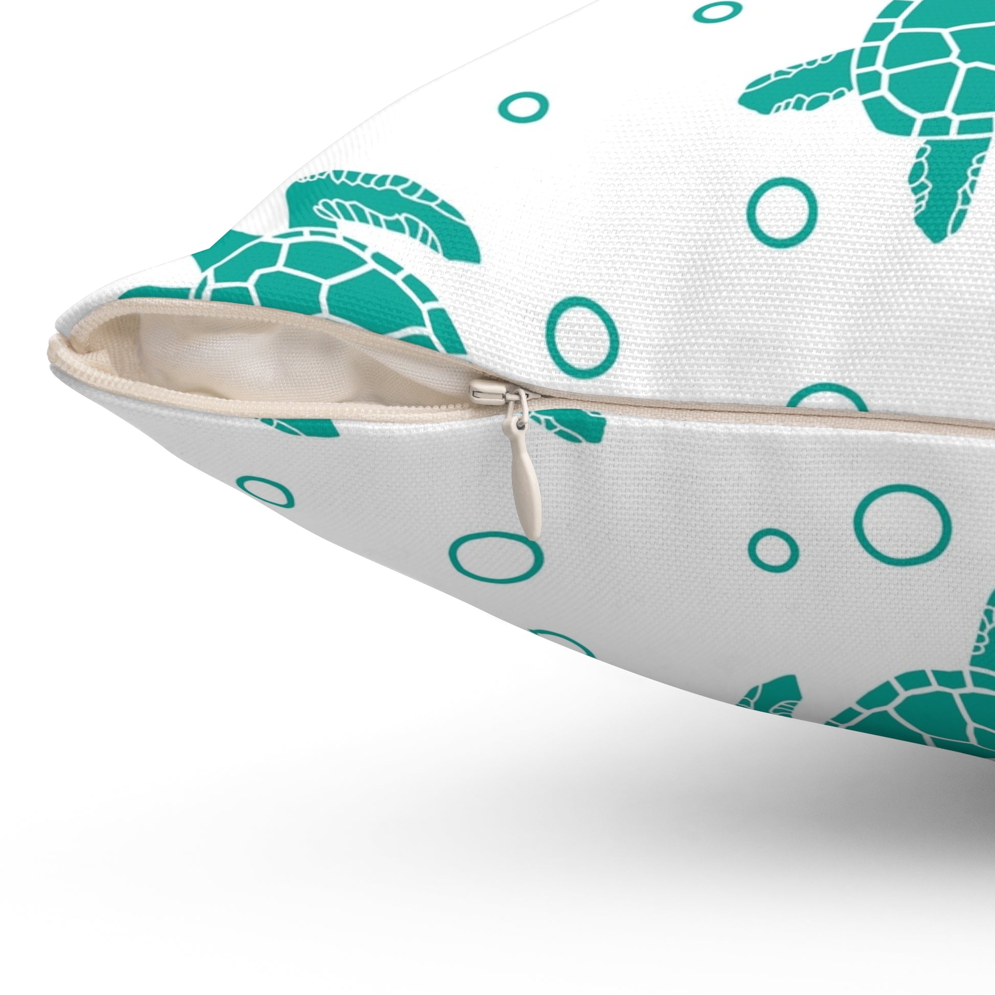 Square pillow, teal sea turtle and ring pattern on white, visible zipper along side