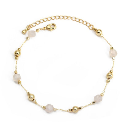 Gold-tone charm bracelet with light pink faceted beads and small heart details