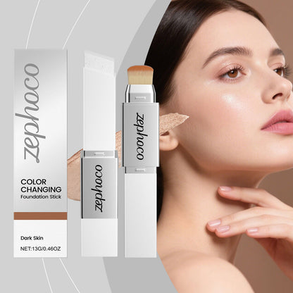 Color-changing foundation stick with brush tip next to boxed packaging on model