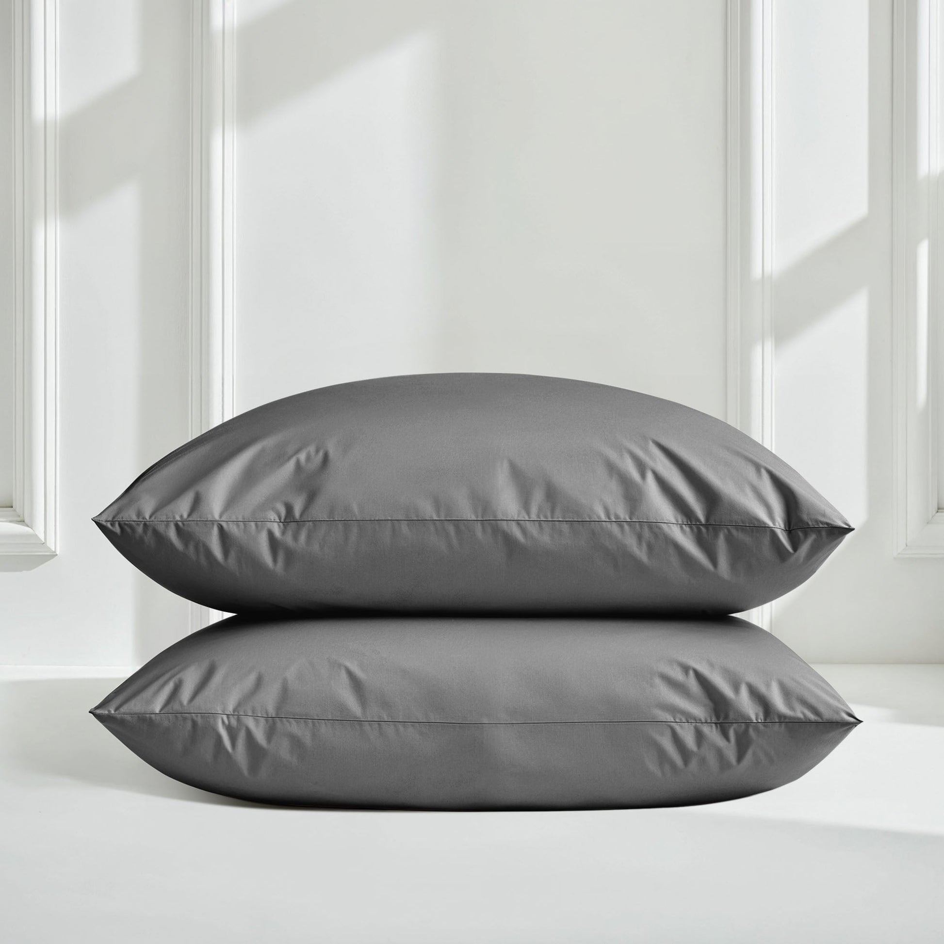 Sateen bedding bundle with two gray pillows, stacked and centered on bedding