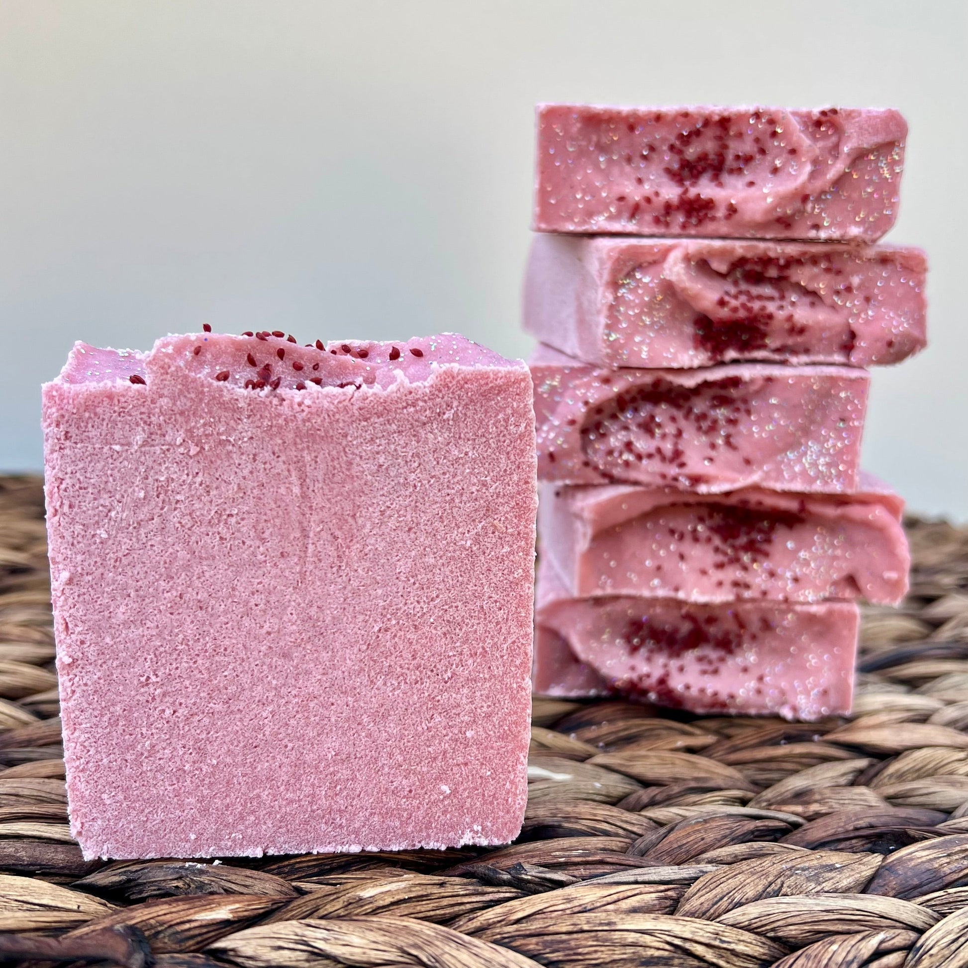 Sea salt soap bar, pink-purple with dark speckles, stacked pieces