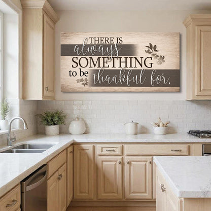 Wall sign with “There is always something to be thankful for.” on a beige woodgrain background.