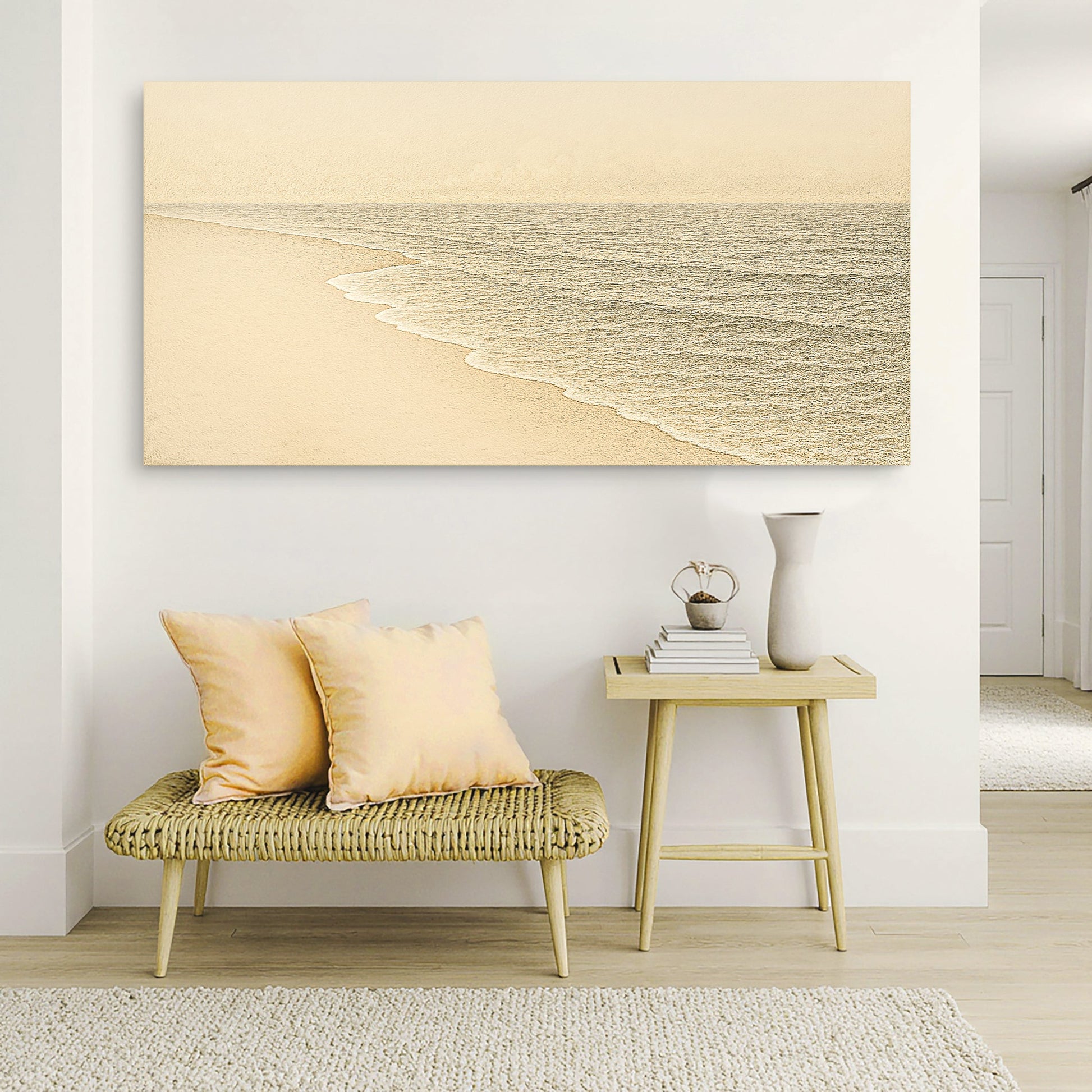 Coastal wall art canvas above a small bench, showing pale sand and gentle sea waves