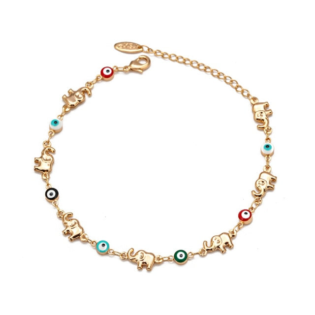 Gold-tone elephant charm bracelet with evil-eye beads and red accent charms