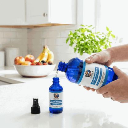 Silver infusion supplement bottle being held next to a small dropper bottle