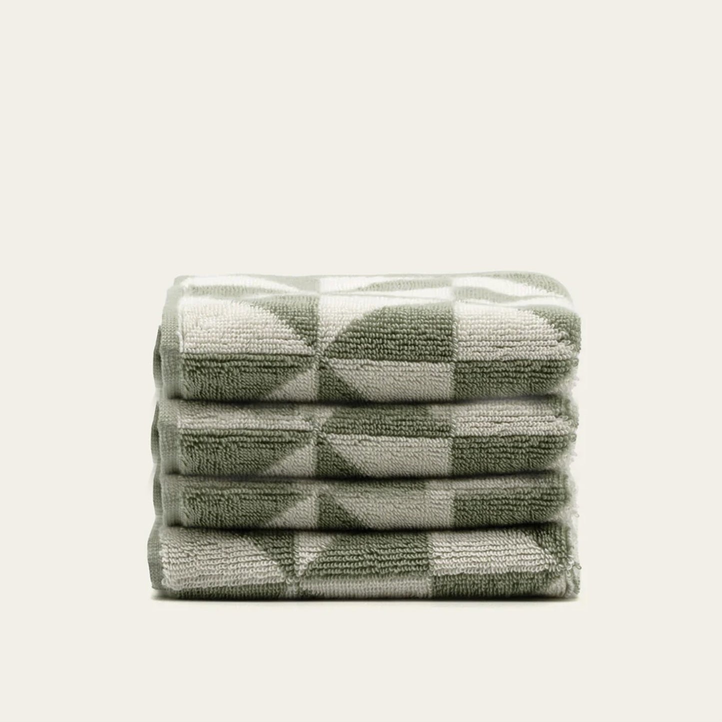 Stacked cotton towels in sage and ecru check-and-triangle design