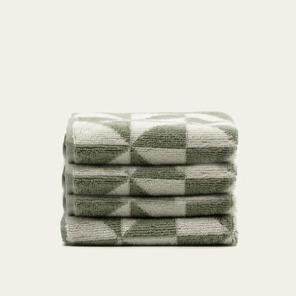 Stacked cotton towels in sage and ecru check-and-triangle design