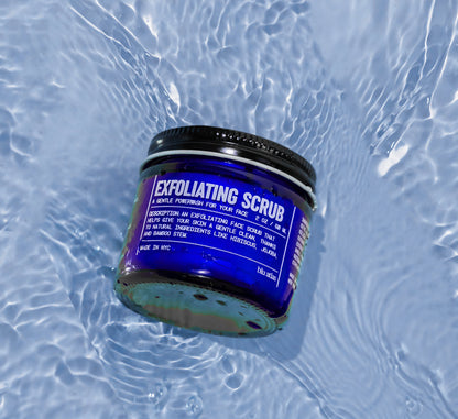 Blue exfoliating scrub jar with black lid and label, front text visible