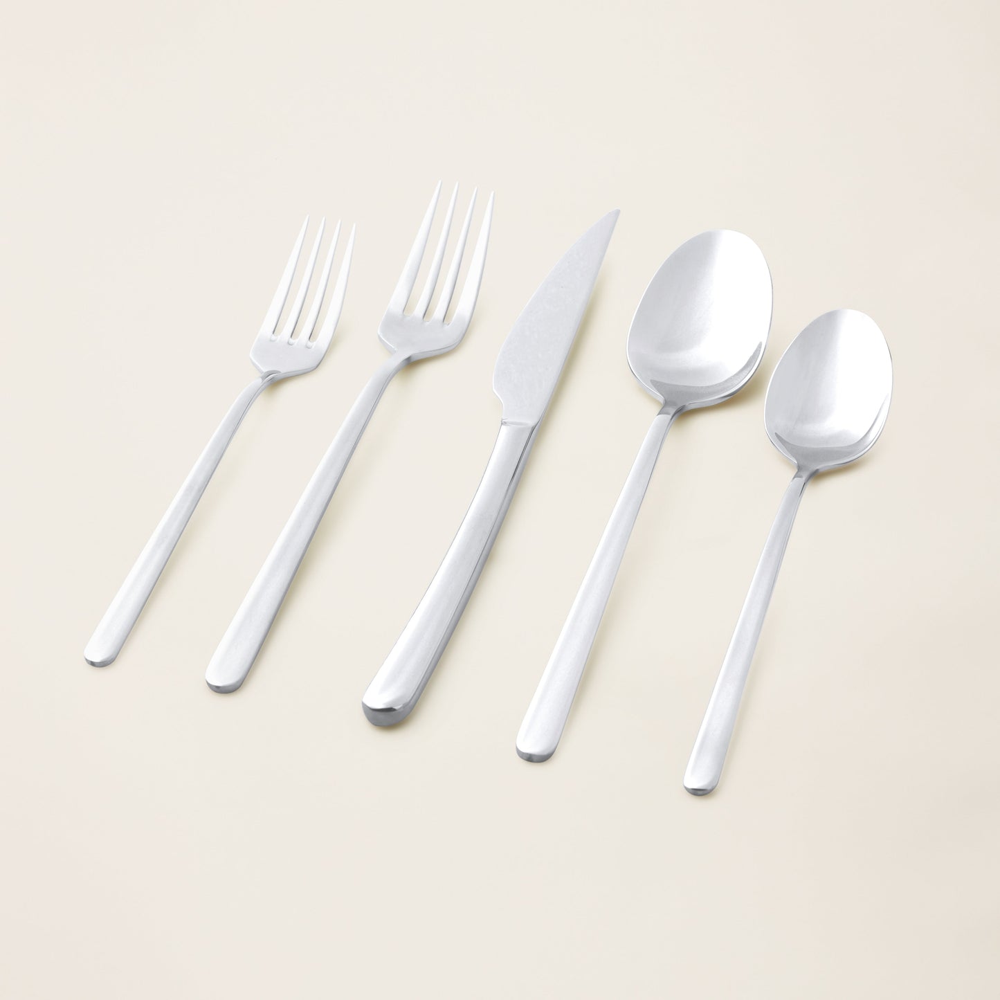 Silver flatware set with forks, knives, and spoons laid out